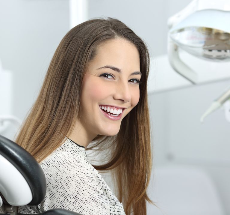 Invisalign service A woman smiling with confidence and straight teeth.