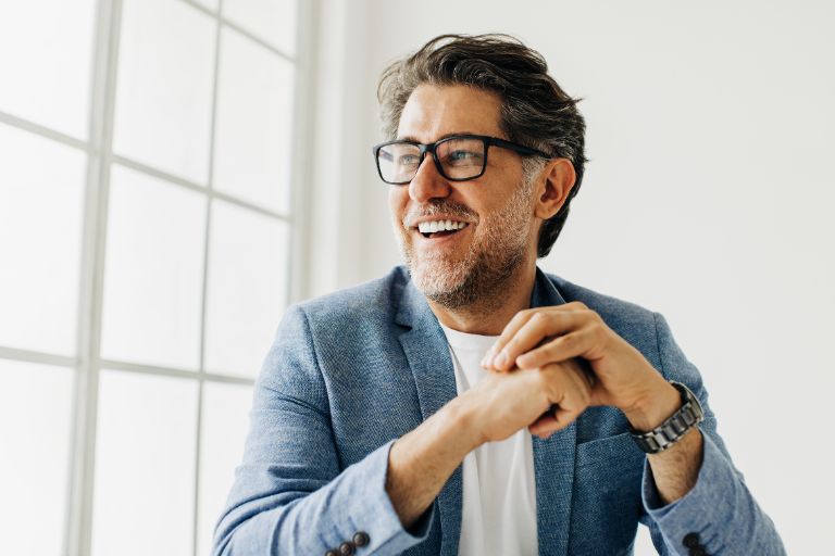 Invisalign & Botox Services A man smiling with confidence—highlighting his bright white and straight teeth.